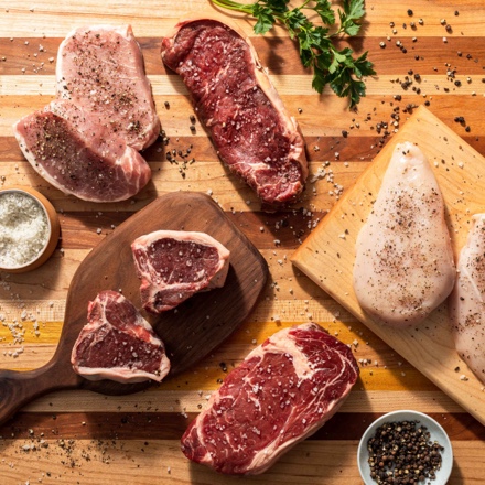various raw proteins on cutting boards